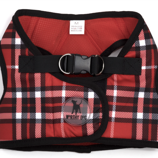 A red, black, and white plaid dog harness with a black adjustable strap and plastic buckle, shown flat on a white background.